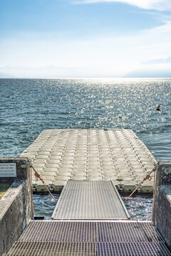 Ponton flottant et rampe d'acc&egrave;s sur le lac L&eacute;man avec scintillement du soleil, Saint-Prex, Suisse