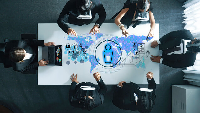 A dynamic business meeting showcases professionals using virtual reality technology with interactive digital elements, representing global connections and collaboration. Trope