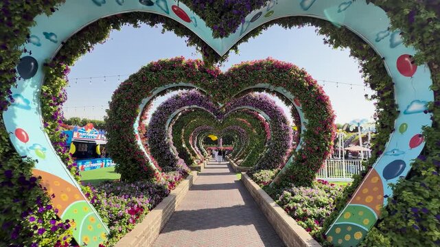 Walking through heart-shaped flower arches, Dubai Miracle Garden, UAE