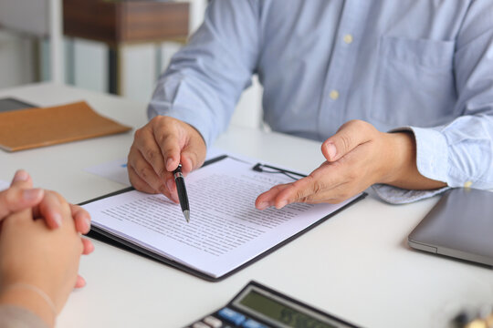 Close-up Business Partners Reviewing Legal Agreement and Signing Contract.