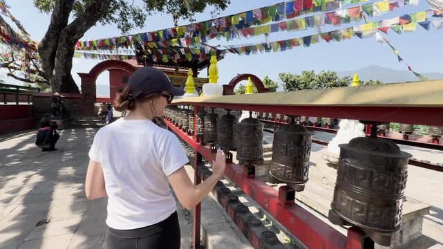 Tourist spinning prayer wheels at Swayambhunath Stupa, Nepal