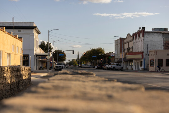 Dos Palos, California, USA - October 28, 2024: Sunset light illuminates an adobe brick bridge over an irrigation canal and historic downtown architecture.