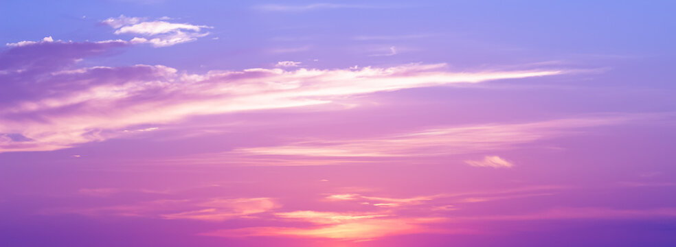 Panoramic sunset sky background with vibrant pink and purple clouds under a soft twilight glow