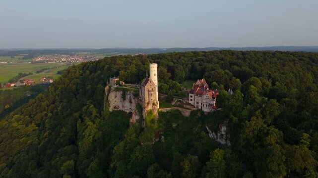 Aerial drone exploration of Lichtenstein Castle, perched above Honau in the Swabian Alps. Captured at dusk with epic scenery and German heritage vibes. Schloss Lichtenstein Wuerttemberg Luftbild. 