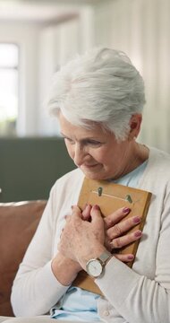 Thinking, hug and old woman with photo frame for grief, nostalgic memory or lonely in retirement. Loss, sad senior widower and embrace picture in home for broken heart, remember history or reflection