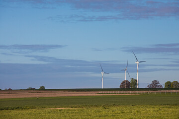 Turbiny wiatrowe na kolorowych wiosennych polach © kubikactive