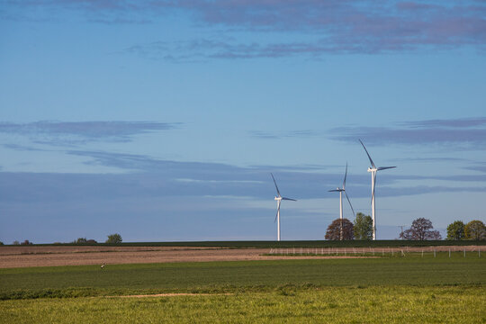 Turbiny wiatrowe na kolorowych wiosennych polach