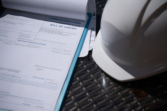 A tablet with documents or bill of lading a protective helmet close-up