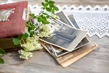 Naklejka premium stack vintage family photographs, aged paper prints, wooden table surface, shallow focus blur, genealogy archive, Nostalgic paper prints, memory collection, nostalgia background, heritage keepsakes