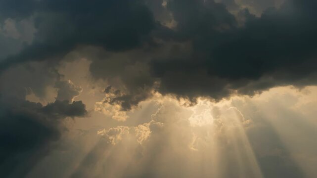 Golden sunbeam sunlight rays piercing dramatic storm cloudscape sky with moody golden clouds