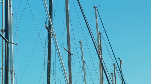 Sailboat masts and rigging against blue sky, marine and nautical background representing sailing, travel, maritime transport and summer coastal lifestyle