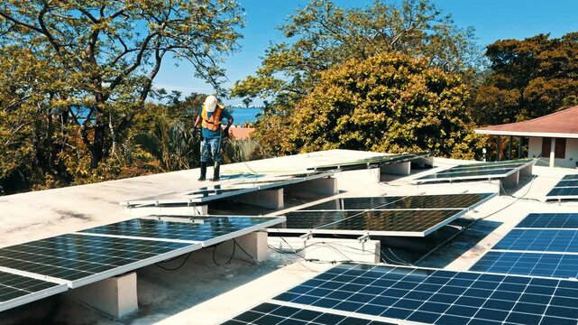 Technician cleaning solar panels on a rooftop