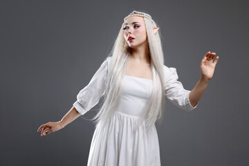 Naklejka premium Beautiful girl dressed as elf on grey background
