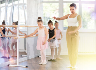 Female dance teacher shows dents a ballet pirouette © JackF