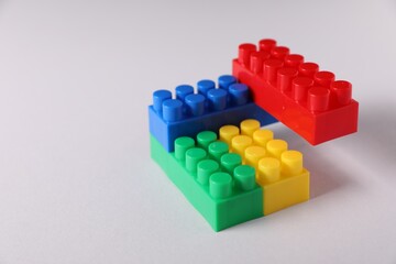 Obraz premium Construction toy. Building blocks on light background, closeup. Space for text
