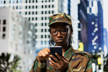 Fototapeta premium Walking on city street, smartphone and army soldier examining map app. Using navigation application, phone and female military officer checking tactical route coordinates in urban environment