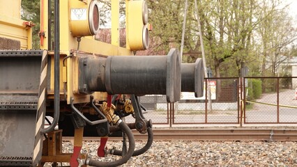 Żółta podbijarka torowa pracuje na modernizowanym odcinku linii kolejowej. Ta specjalistyczna maszyna precyzyjnie stabilizuje podłoże pod szynami, dbając o bezpieczeństwo i trwałość infrastruktury © tomo81