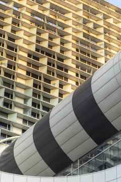 View of modern architectural details featuring a geometric grid facade and a curved striped structure in Taipei City, Taiwan.