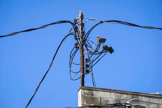 Old worn electrical power wires on urban building