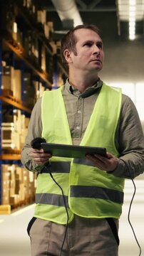 Vertical Video Warehouse staff scanning barcodes and shipment details on tablet, checking AWB labels for inventory before delivery and transportation. Fulfillment center distribution operations.