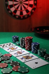 Fototapeta premium Casino chips and playing cards on green table, closeup