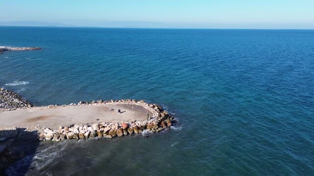 Aerial View of Man Fishing by the Sea in Izmir Turkiye Drone Shot