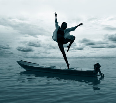 silhouette of one  Woman jumping off dancing on iron motor boat into ocean alone ballerina girl jump into clear blue water enjoying active lifestyle summer holiday travel vacation adventure