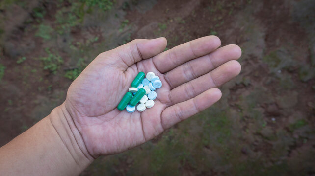 Various pills in the palm of the hand, the concept of overdose and addiction