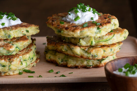 Stack of zucchini fritters with sour cream and chives