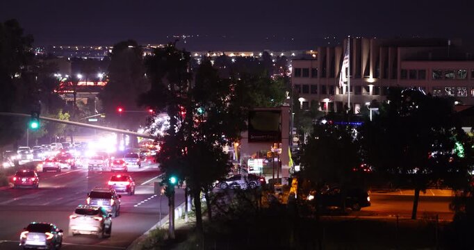 Evening traffic passes through the buildings of downtown Moreno Valley, California, USA.