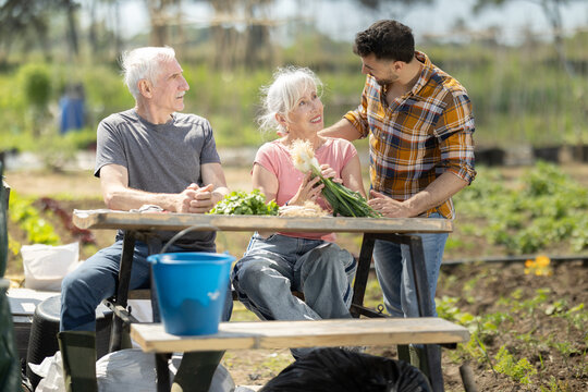 Happy family of farmers sits at the table and discusses current affairs