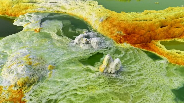 Aerial view of the colorful hydrothermal pools and salt formations in the Danakil Desert with vibrant yellow and green mineral deposits in Dalol, Afar, Ethiopia.