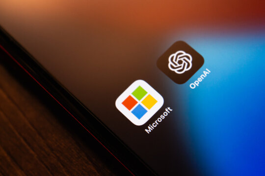Mexico City, MEXICO - May 5 2026 : Close-up of a smartphone screen displaying the Microsoft and OpenAI icons, placed on a wooden surface.