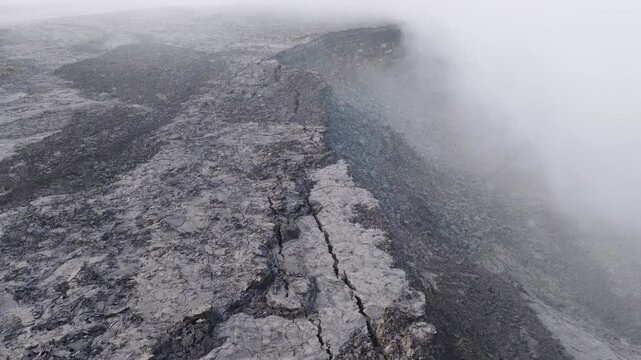 Aerial view of Erta Ale Volcano with steam rising from the crater and dark volcanic rock in Danakil Desert, Afar, Ethiopia.