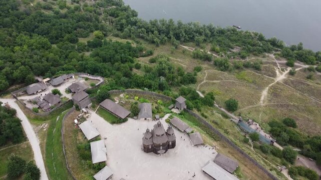Epic drone panorama of Khortytsia Island with a historic Cossack settlement, winding river, and dense forest in Ukraine