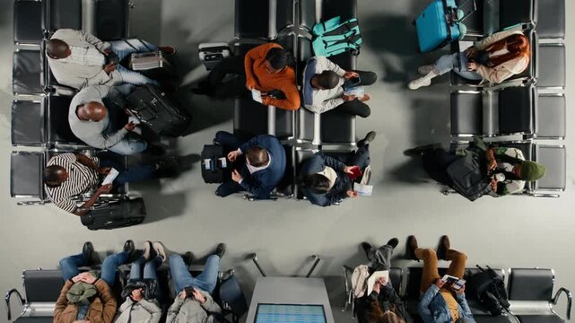 Going to boarding gate, wheeled luggage and multiethnic travelers in airport hub. Preparing for boarding call, standing up from metal benches and diverse people in airport lounge