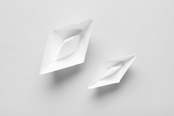 Naklejka premium White paper boats on grey background