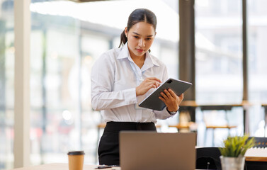 Fototapeta premium Young businesswoman using digital tablet in modern office