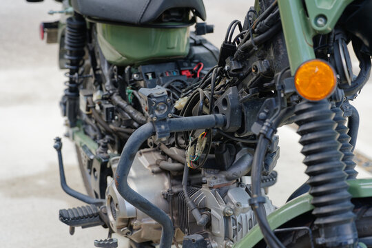 Close-up of disassembled motorcycle engine and wiring during outdoor maintenance work