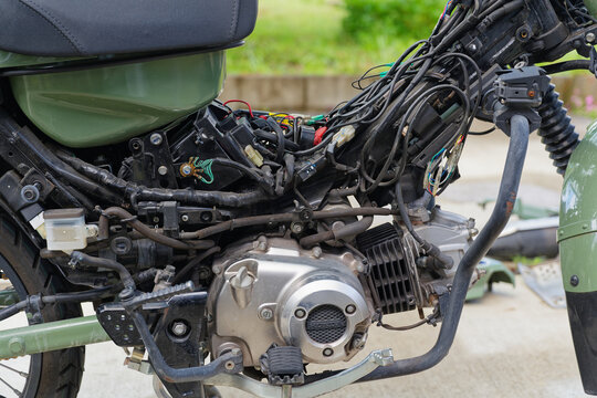 Close-up of disassembled motorcycle engine, wiring and mechanical parts during maintenance work