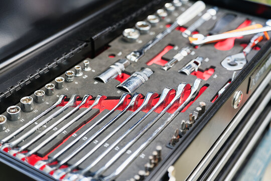 Close-up of organized socket wrench and spanner tool set in an open tool chest for maintenance work