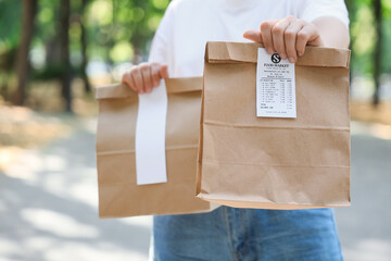 Woman with paper bags outdoors. Food delivery service