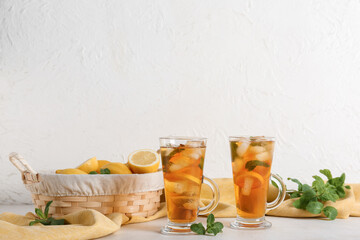 Fototapeta premium Glass cups of fresh iced tea on light background