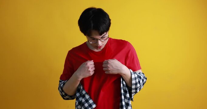 Young guy suffering from sweating on orange background
