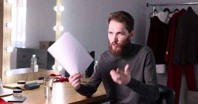 Actor with script rehearsing his lines in dressing room