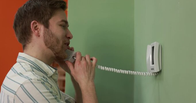 Young man answering intercom call at home