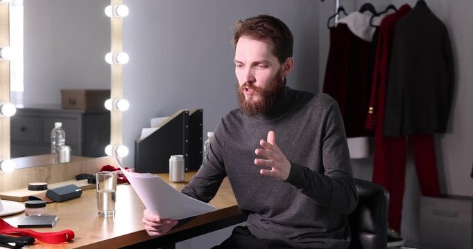 Actor with script rehearsing his lines in dressing room