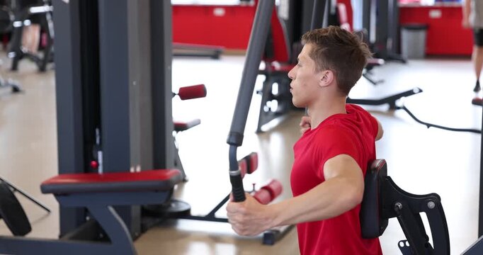 Man sweating while exercising with chest press machine in gym