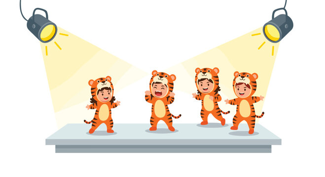 Four happy children wearing adorable orange tiger costumes dance and perform on a grey stage under the warm glow of two bright yellow spotlights.