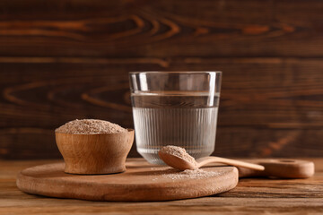 Glass of water with psyllium husk on wooden background © Pixel-Shot